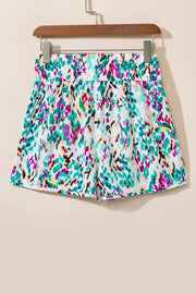 White running shorts with a colorful abstract brushstroke print and elastic waistband.