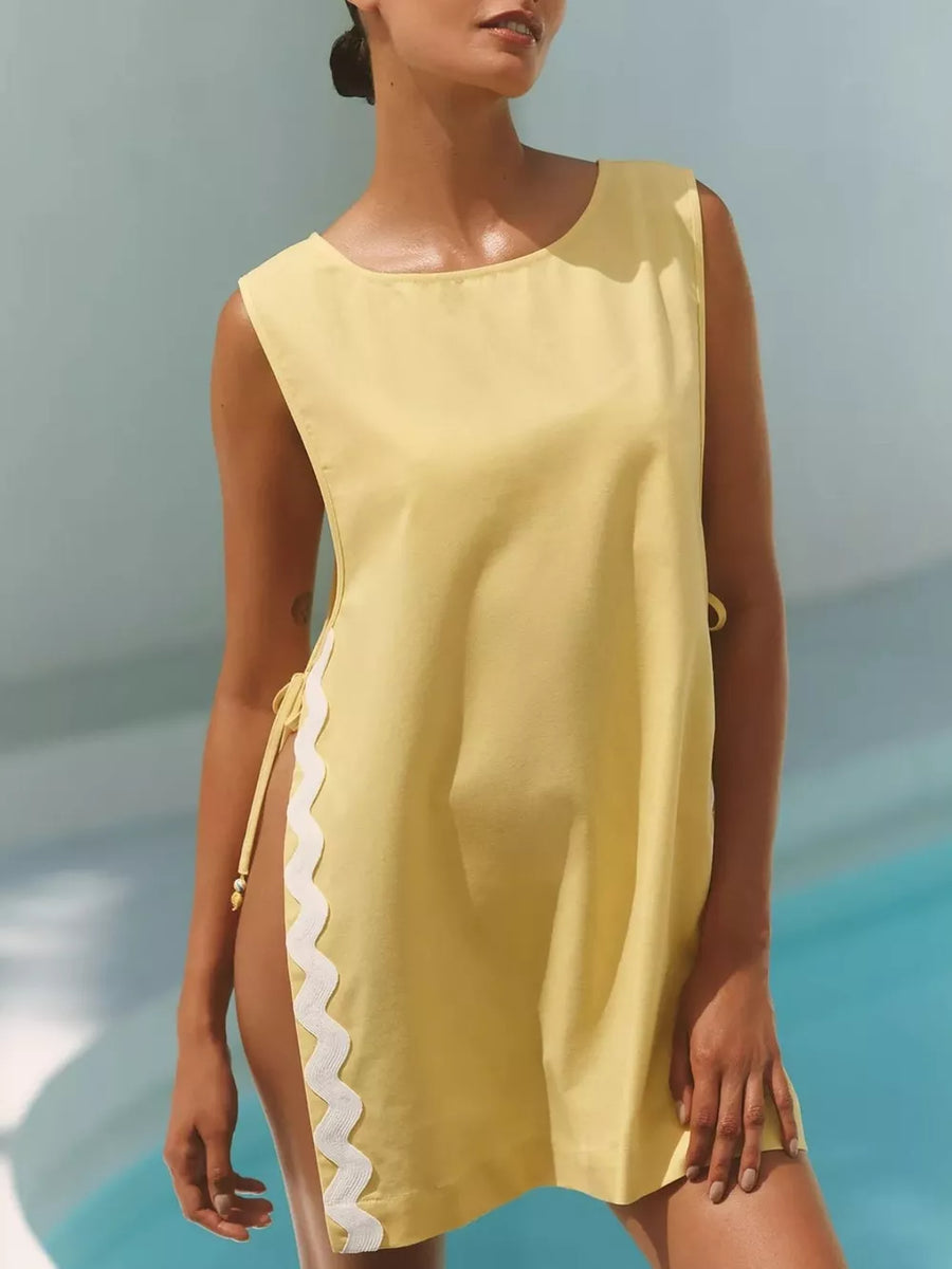 Yellow sleeveless tunic with white scalloped trim and side ties