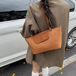 Suede flap tote bag in brown with a contrast flap detail and single strap.