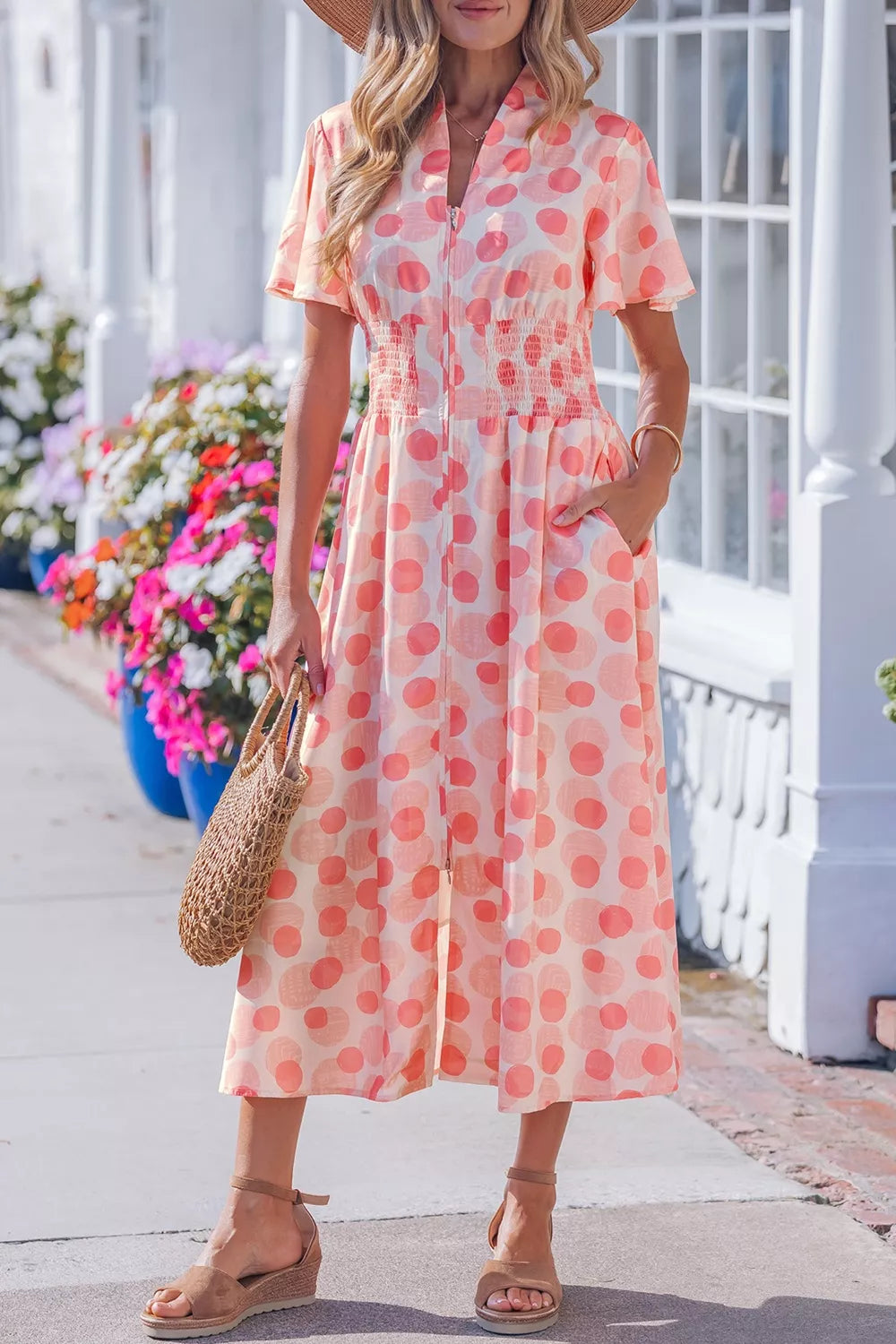 Charming puff sleeve midi dress with pockets in a peach and pink polka dot print, smocked waist, and zip front.
