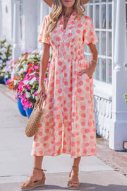 Charming puff sleeve midi dress with pockets in a peach and pink polka dot print, smocked waist, and zip front.