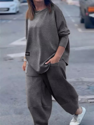 Dark gray crew neck two-piece lounge set with pockets and a casual fit.