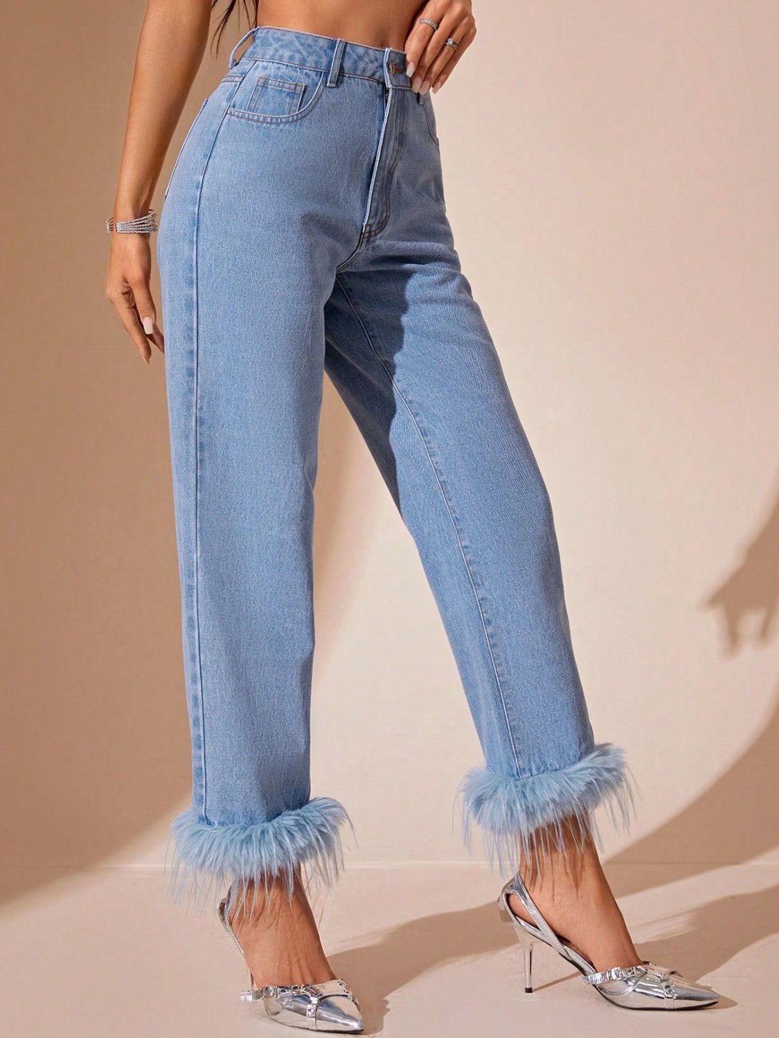 Light wash denim jeans with feather trim cuffs and high-rise waist.