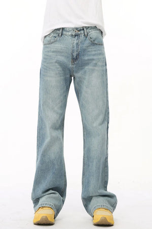 Wide leg denim bell bottom jeans in medium wash, styled with yellow sneakers.