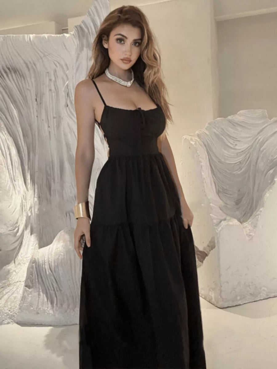 Black backless maxi dress with crisscross detail and tiered skirt.