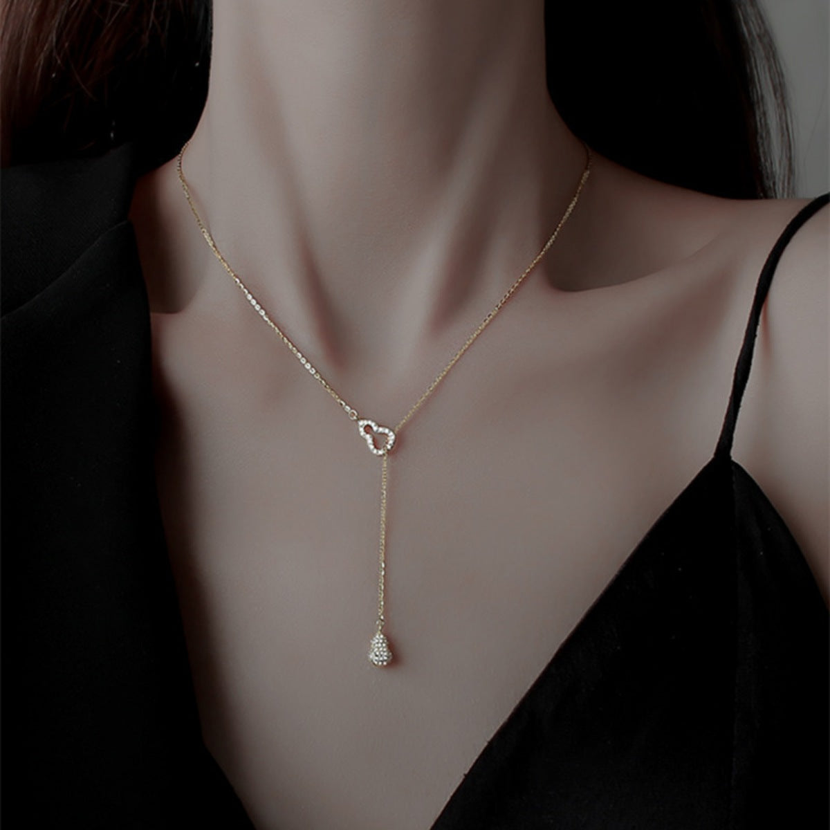 Gold zircon pendant necklace with double gourd charm and teardrop detail.