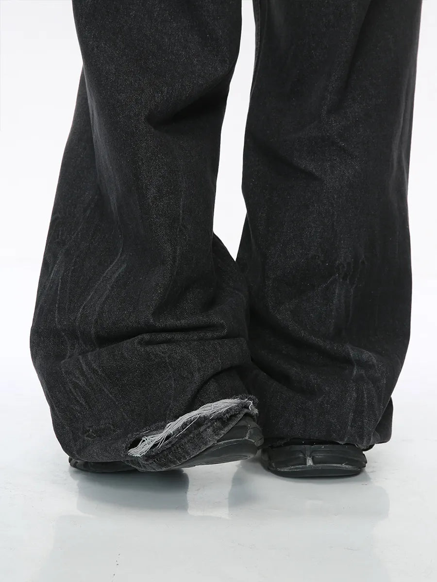 Dark denim palazzo trousers with distressed hem detail.