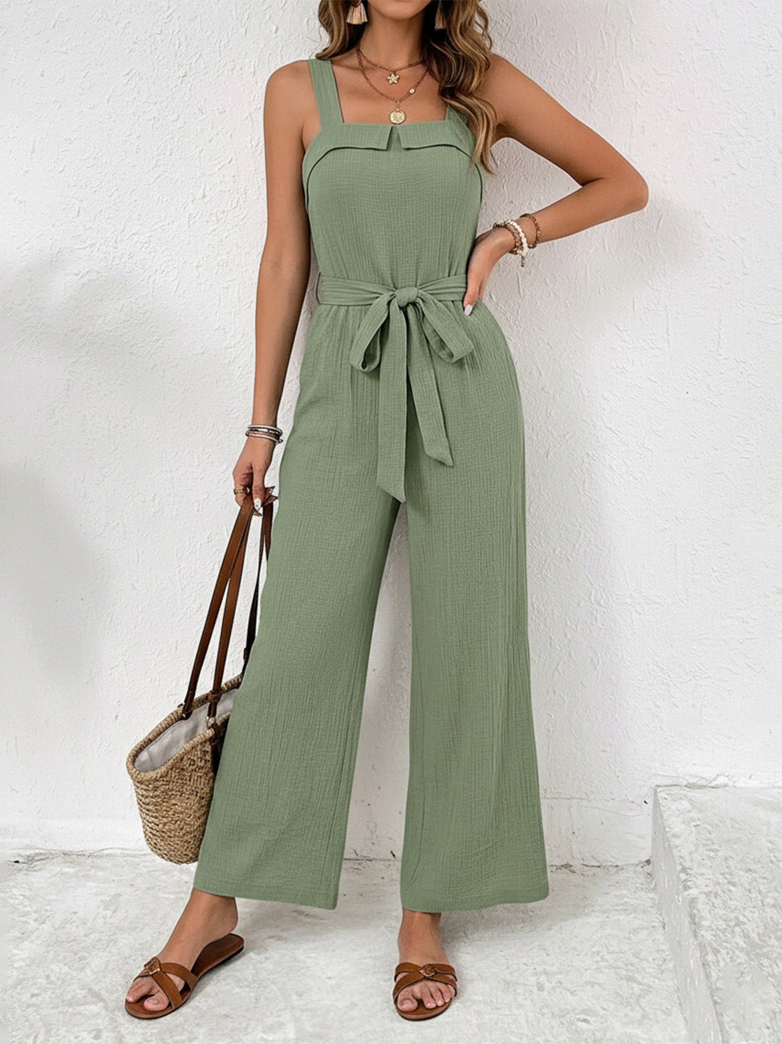 Sage green crinkled tie waist wide leg jumpsuit with square neckline and wide straps.