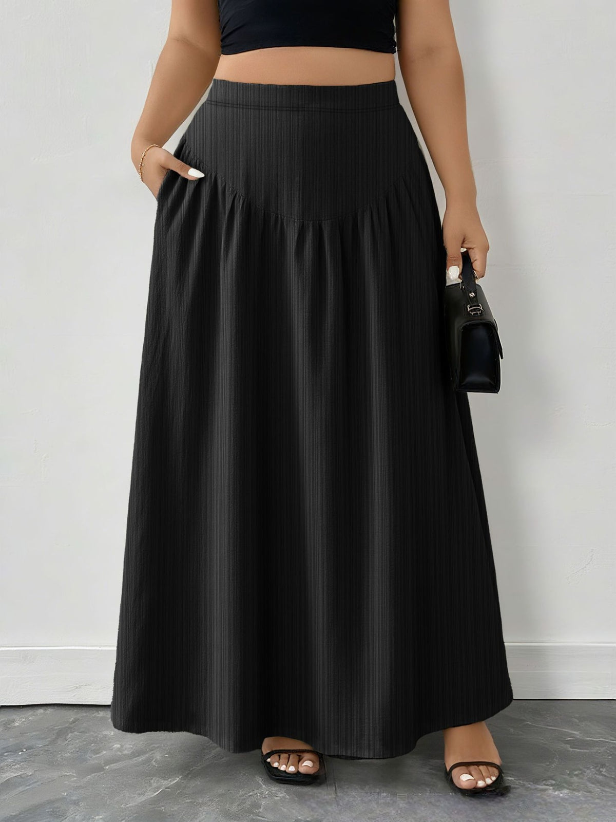 Black ribbed maxi skirt with pockets and an A-line cut.