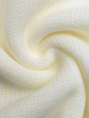 Cream acrylic knit sweater detail showing textured stitches.