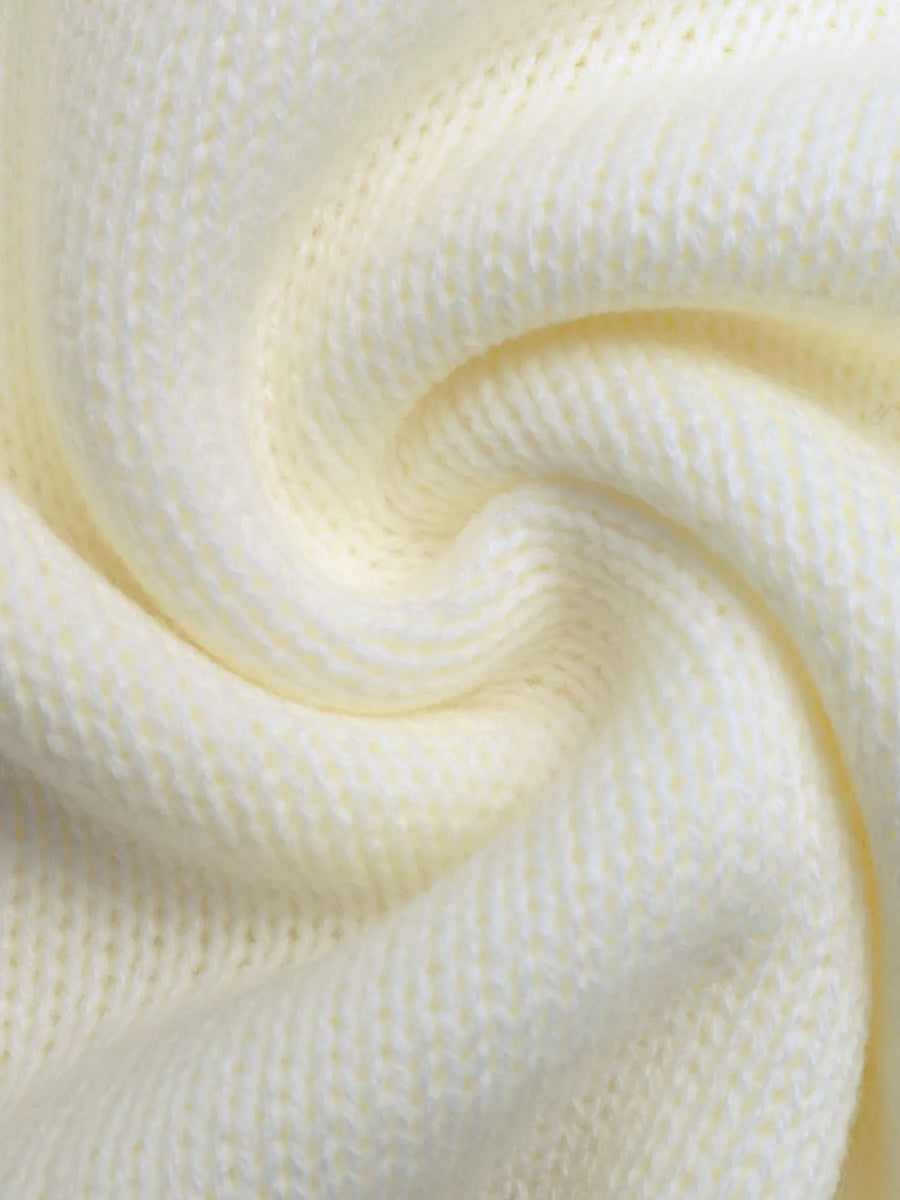 Cream acrylic knit sweater detail showing textured stitches.