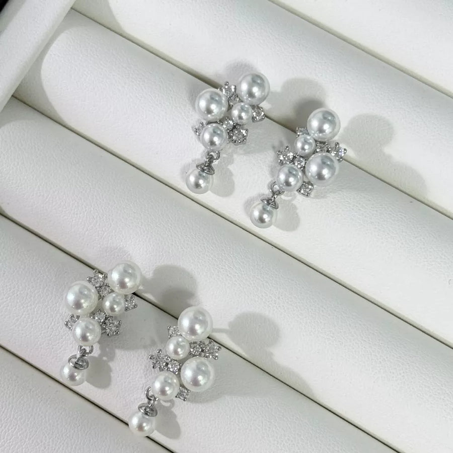 Sophisticated pearl and zircon earrings in light gray and white feature a cluster design with dangling pearls.