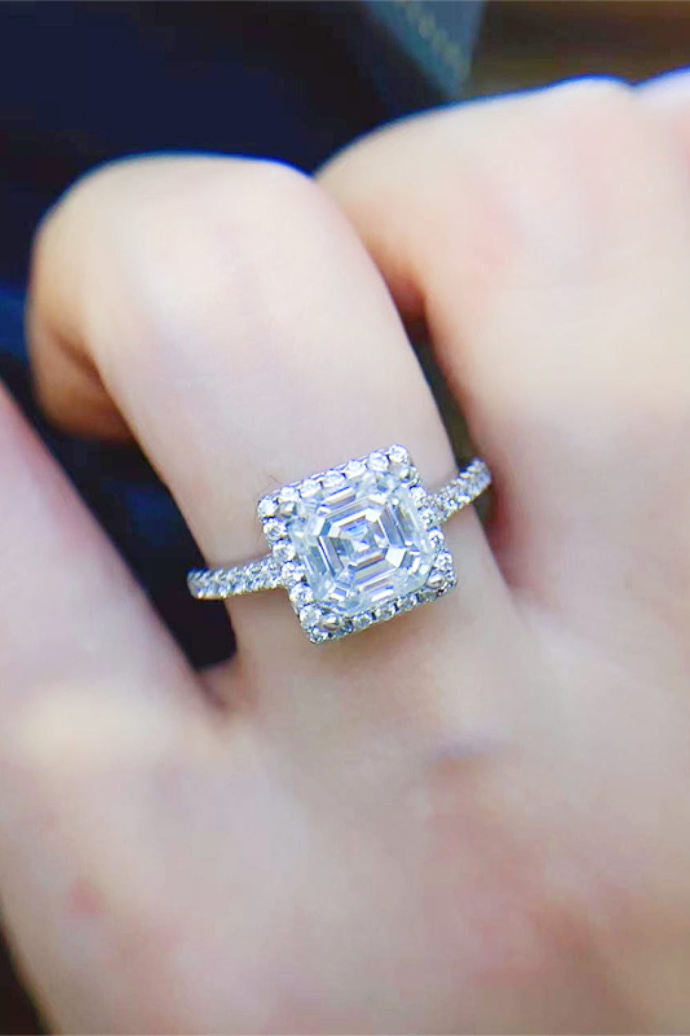 Silver Asscher cut moissanite halo ring with sparkling pavé band.