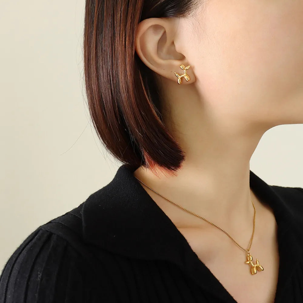 Gold balloon dog stud earrings with matching pendant necklace.