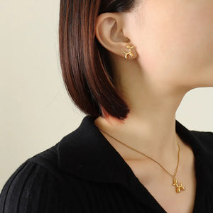 Gold balloon dog stud earrings with matching pendant necklace.