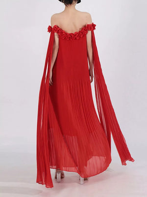 Red off-shoulder maxi dress with floral applique neckline and cape sleeves.