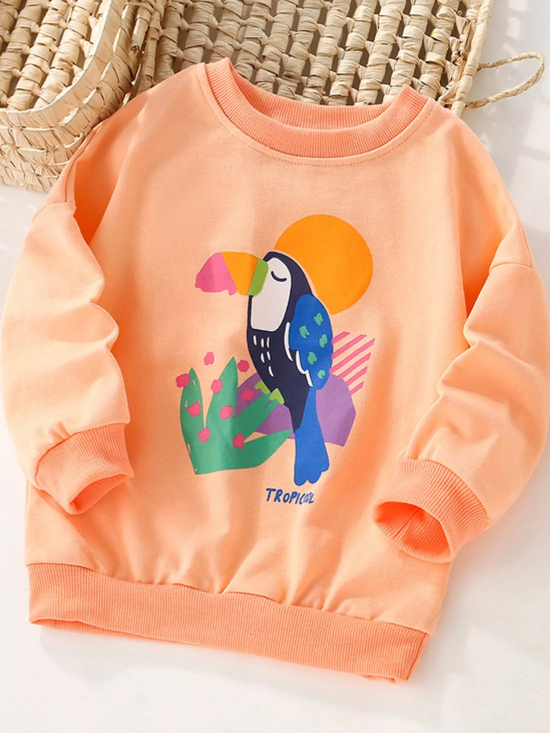 Tangerine crew neck sweatshirt for kids with a toucan graphic and tropical design.