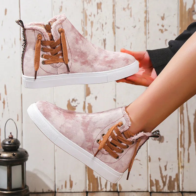 Blush pink canvas zip-up sneaker booties with lace-up detail and faux fur trim.