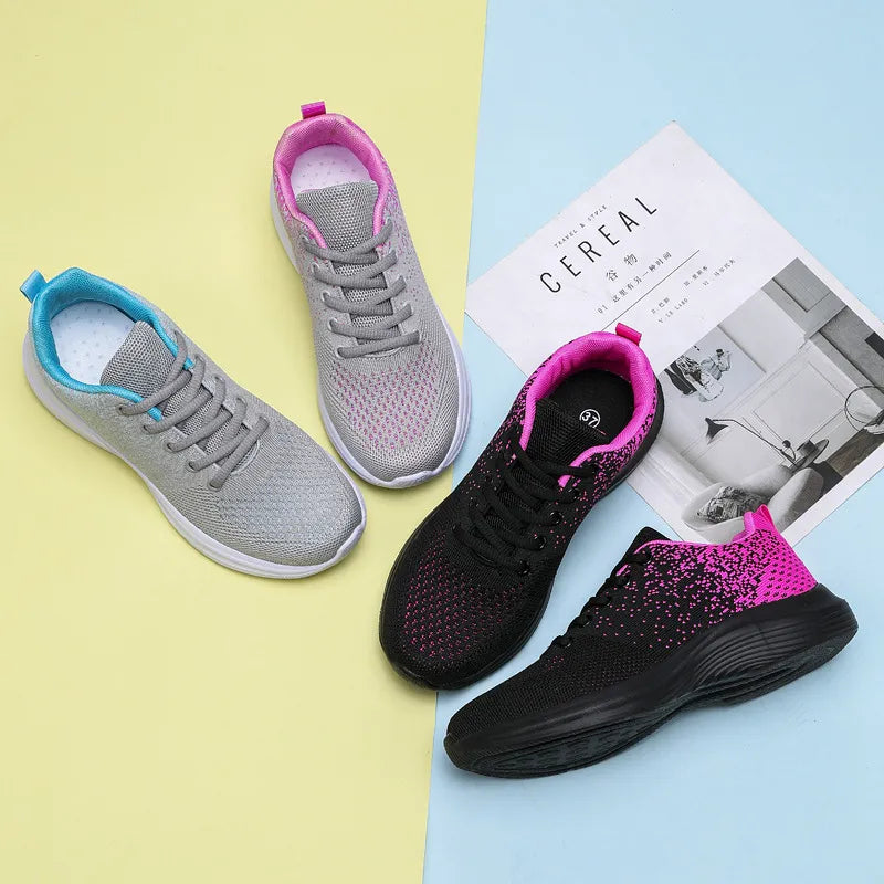 Light gray and black knit athletic shoes with pink and blue accents.