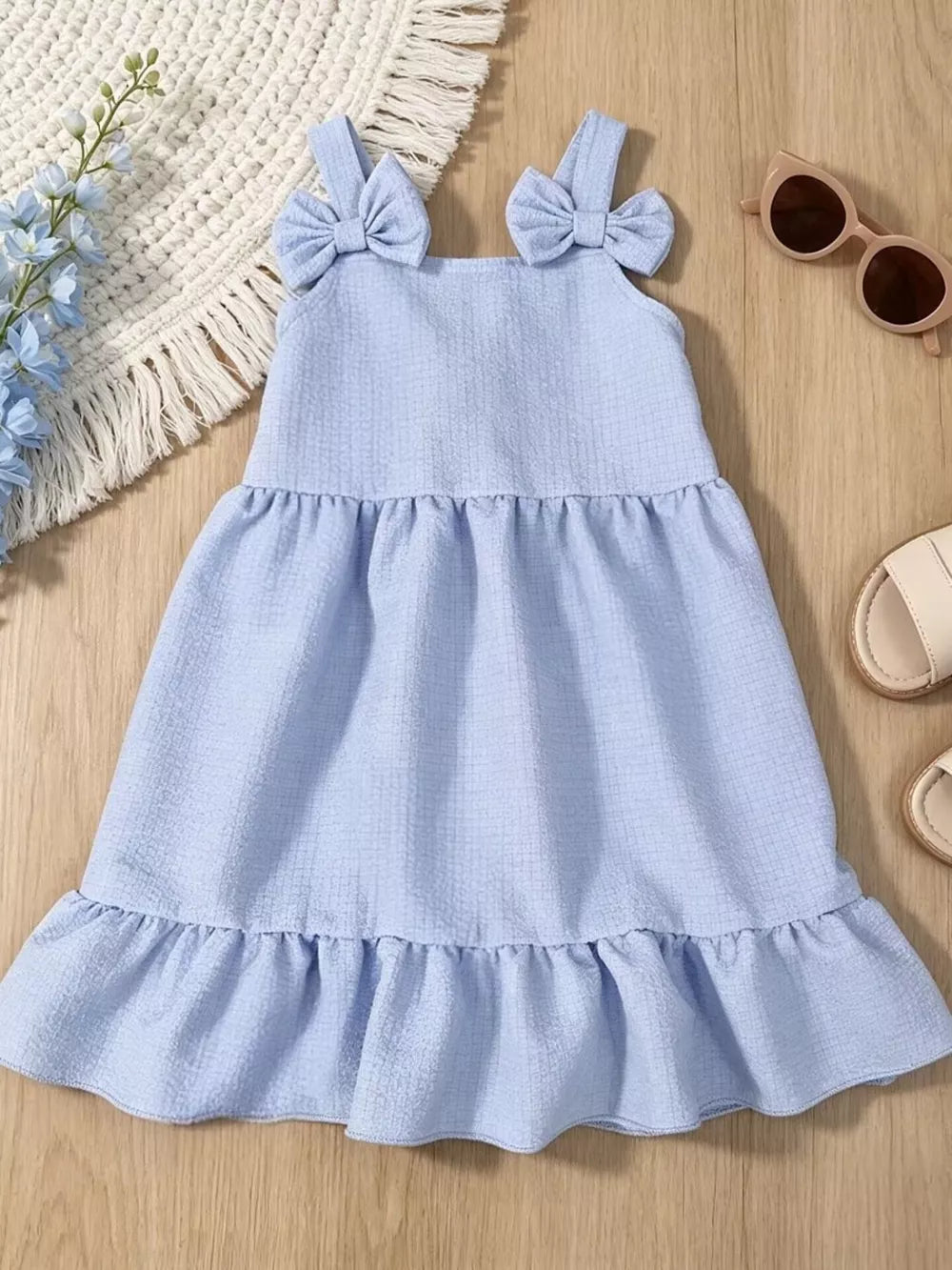 Baby dress in sky blue with bowknot straps and ruffle hem