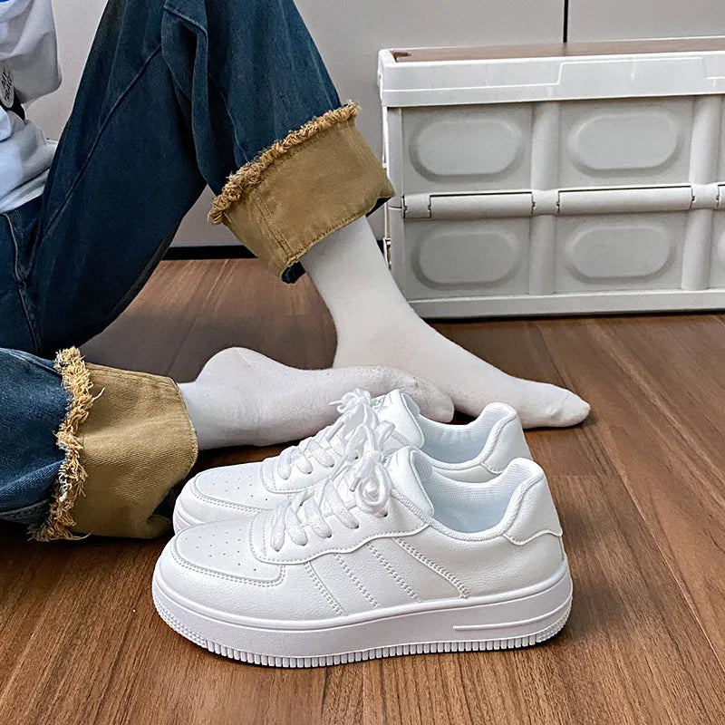 White minimalist platform sneakers with perforated details and lace-up closure.