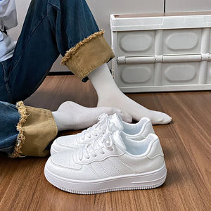 White minimalist platform sneakers with perforated details and lace-up closure.