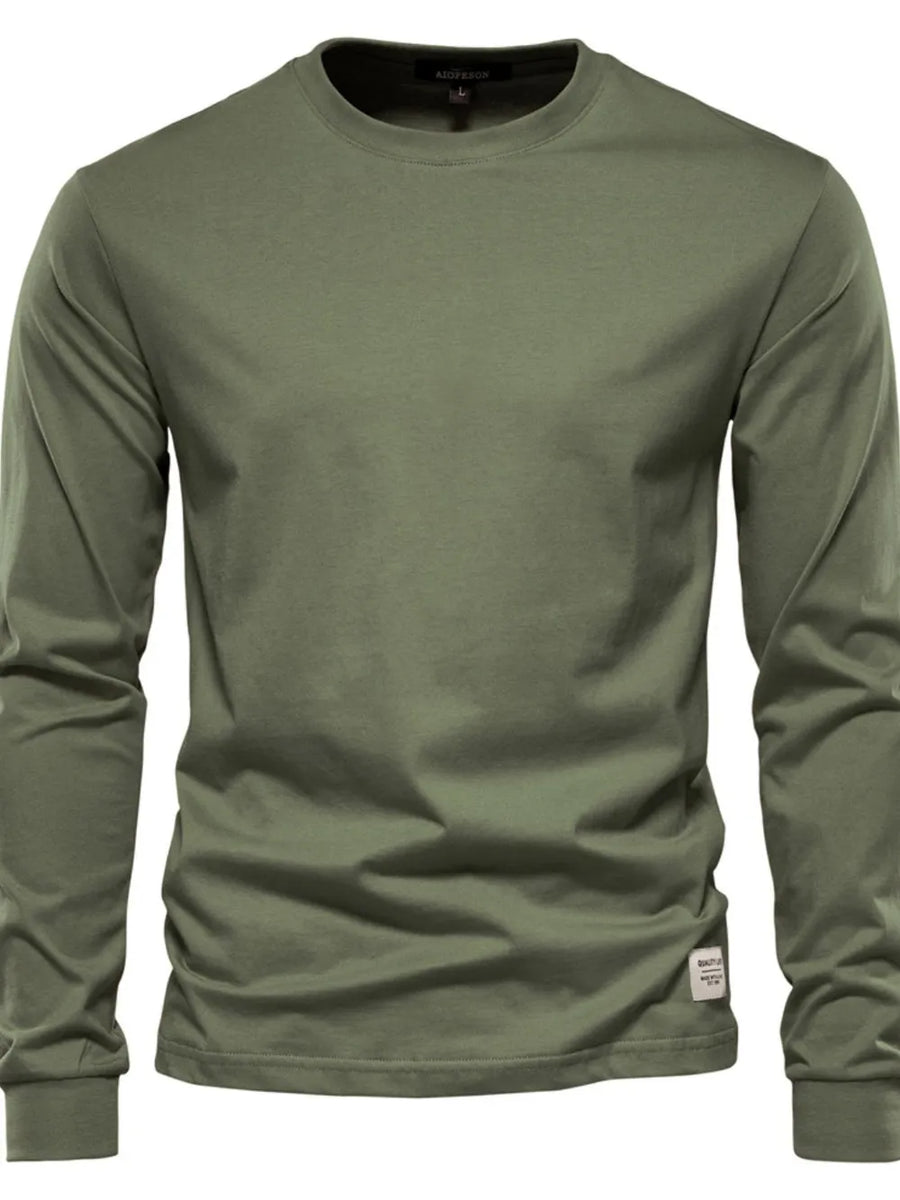 Moss green crewneck long sleeve t-shirt with a small tag detail on the hem.