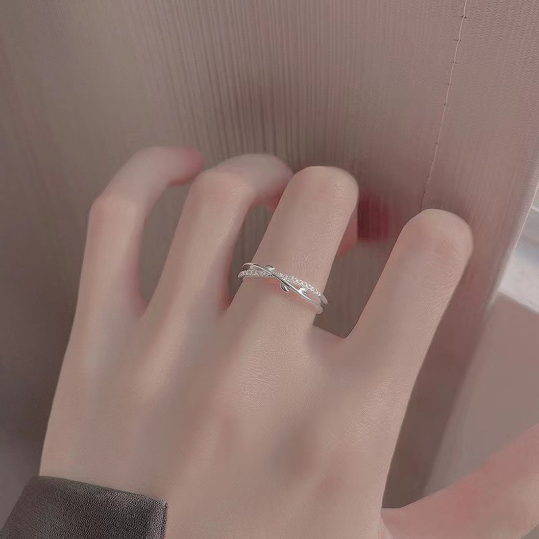 Sterling silver crossover ring with delicate pave detail on a woman's finger