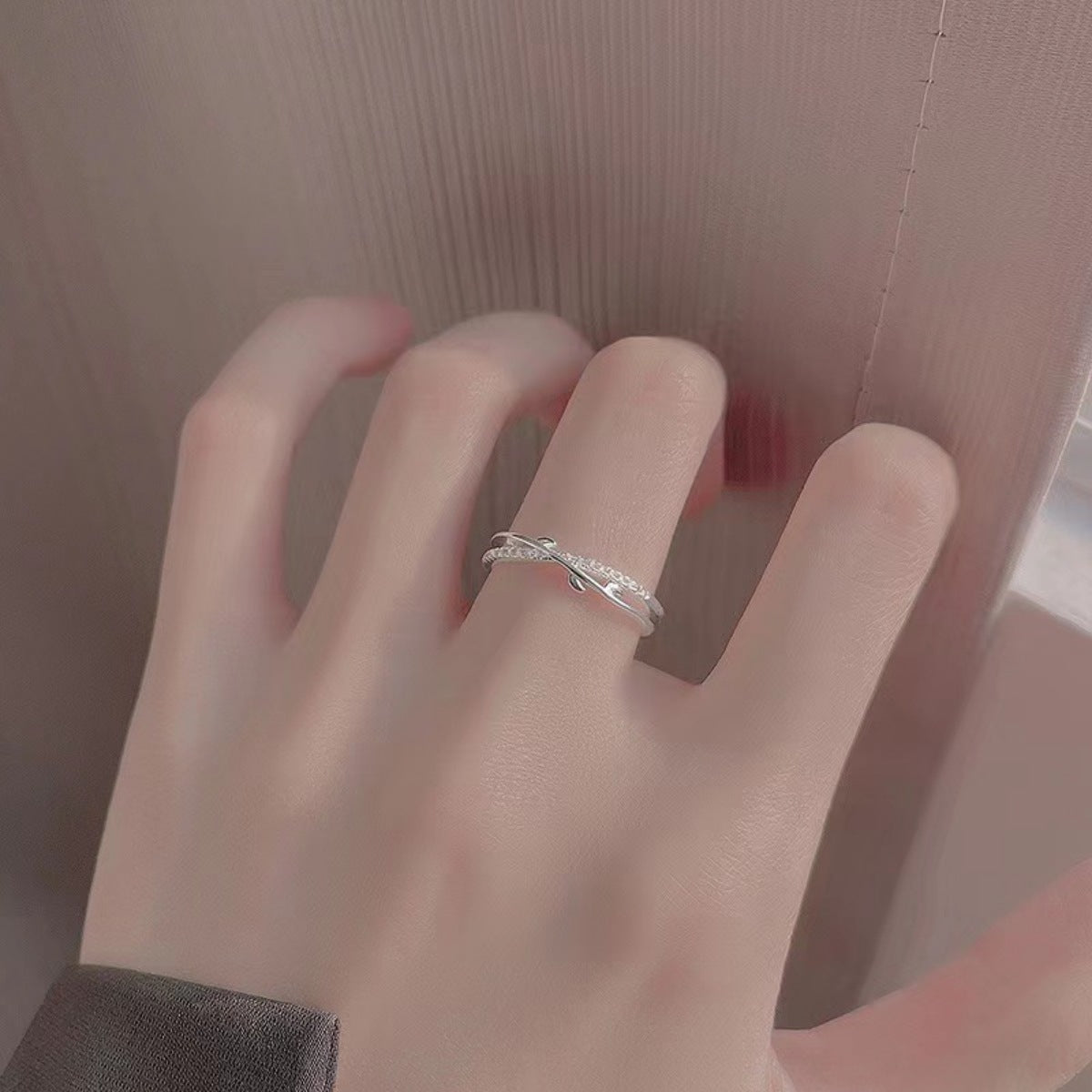 Sterling silver crossover ring with delicate pave detail on a woman's finger