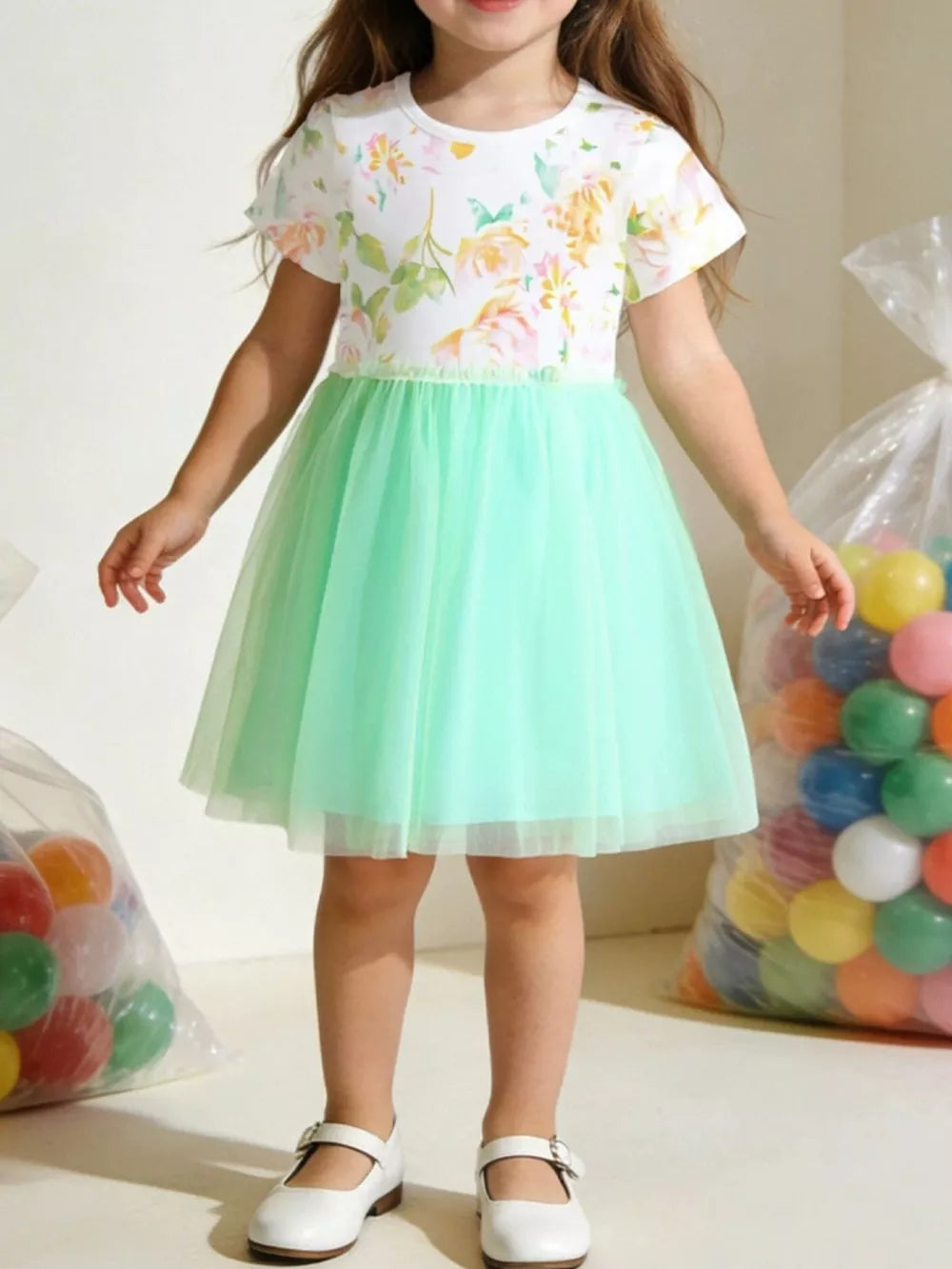Toddler girl's mint green tulle dress with floral print bodice and short sleeves.