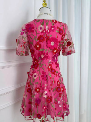 Pink floral embroidered mesh dress with short sleeves and a round neckline.