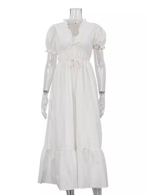 White tiered maxi dress with puff sleeves, ruffled neckline, and drawstring waist