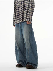 Men's blue wide leg cotton jeans with a relaxed fit, styled with a plaid shirt.