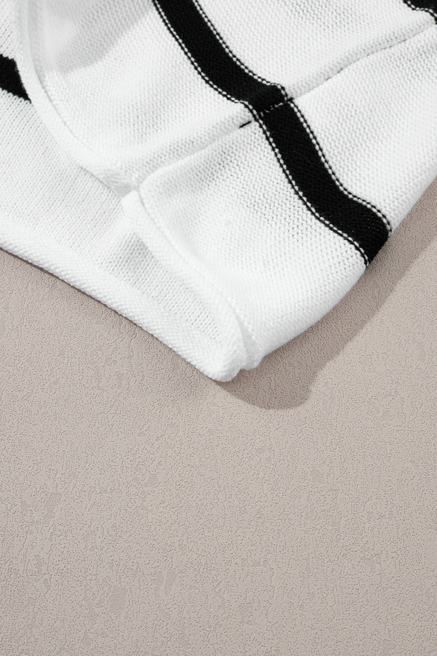White knit shell top with black horizontal stripes and a textured knit detail.