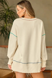 Beige graphic cross stitch sweatshirt with contrast stitching detail and raw hem.