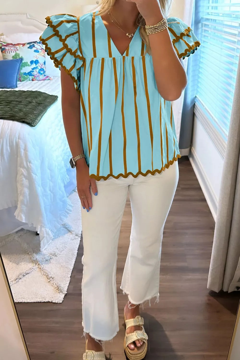Light blue cotton blend blouse with brown vertical stripes, V-neck, and ruffled scalloped sleeves.