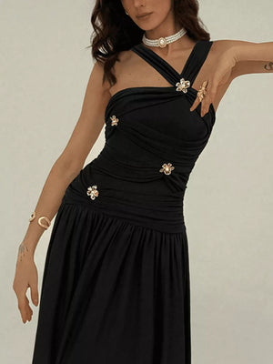 Black ruched sleeveless maxi dress with floral embellishments and a pull-over closure.