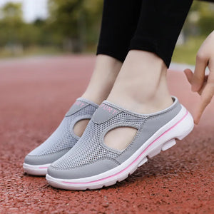 Gray mesh mule slippers with cut-out detail and pink accents