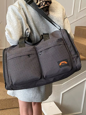 Chic medium plaid duffel bag with multiple exterior pockets and a small orange logo patch.