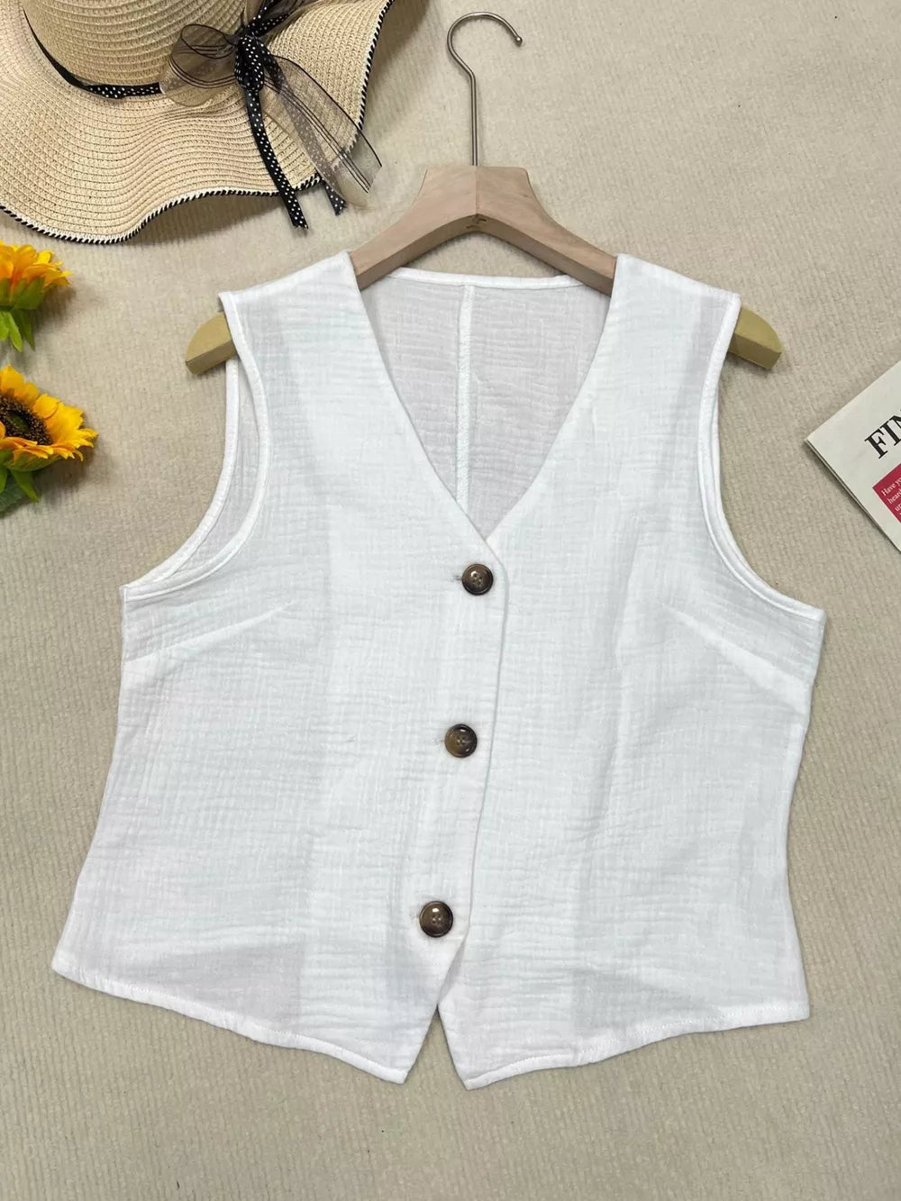 White textured vest with tortoiseshell buttons, V-neck, cropped length