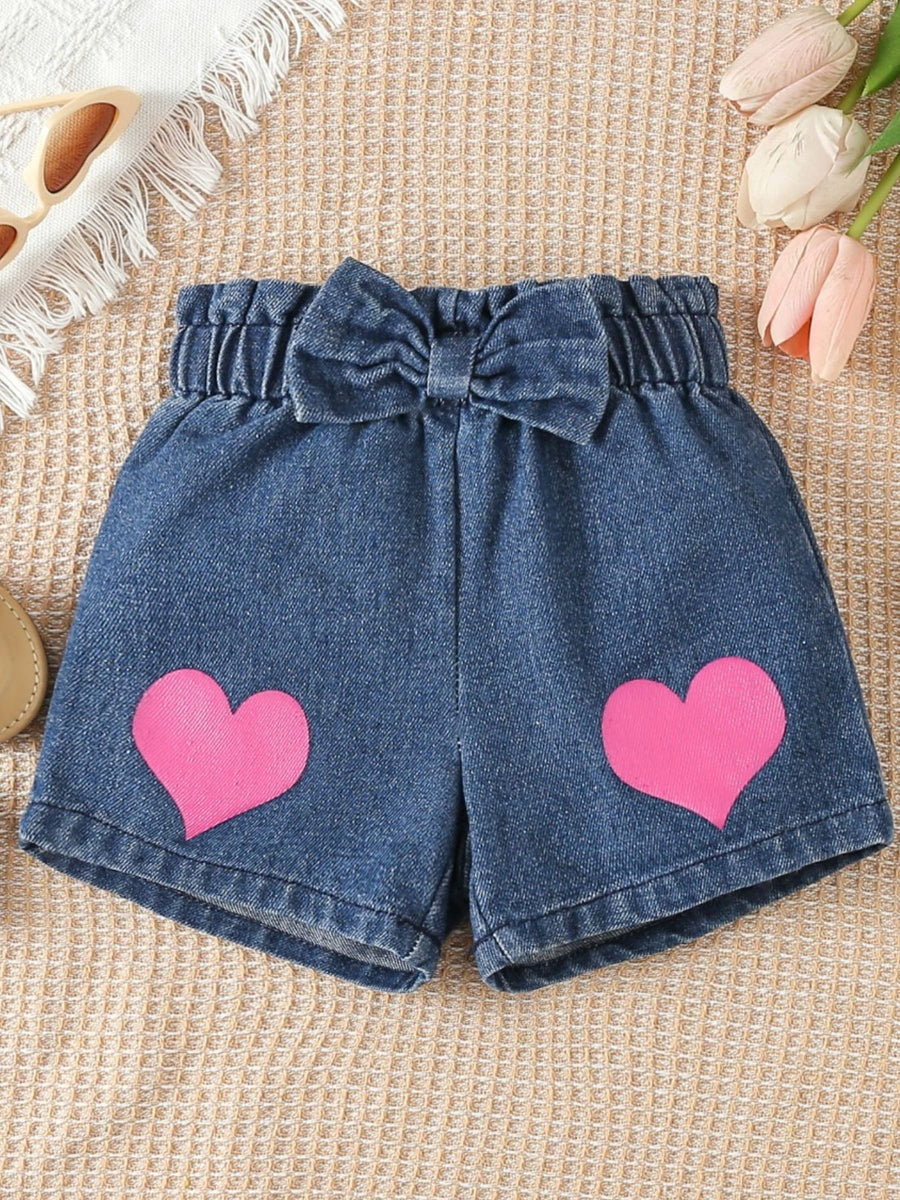 Denim shorts with pink hearts and a bow detail.