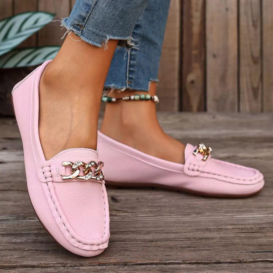 Pink round-toe loafers with gold chain detail and contrast stitching.