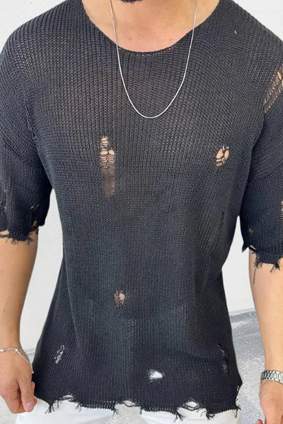 Black open-knit crewneck tee with distressed holes and raw hem