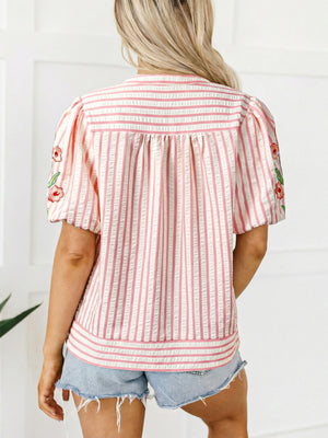 Pink and white striped blouse with floral embroidery on puff sleeves and gathered back detail.