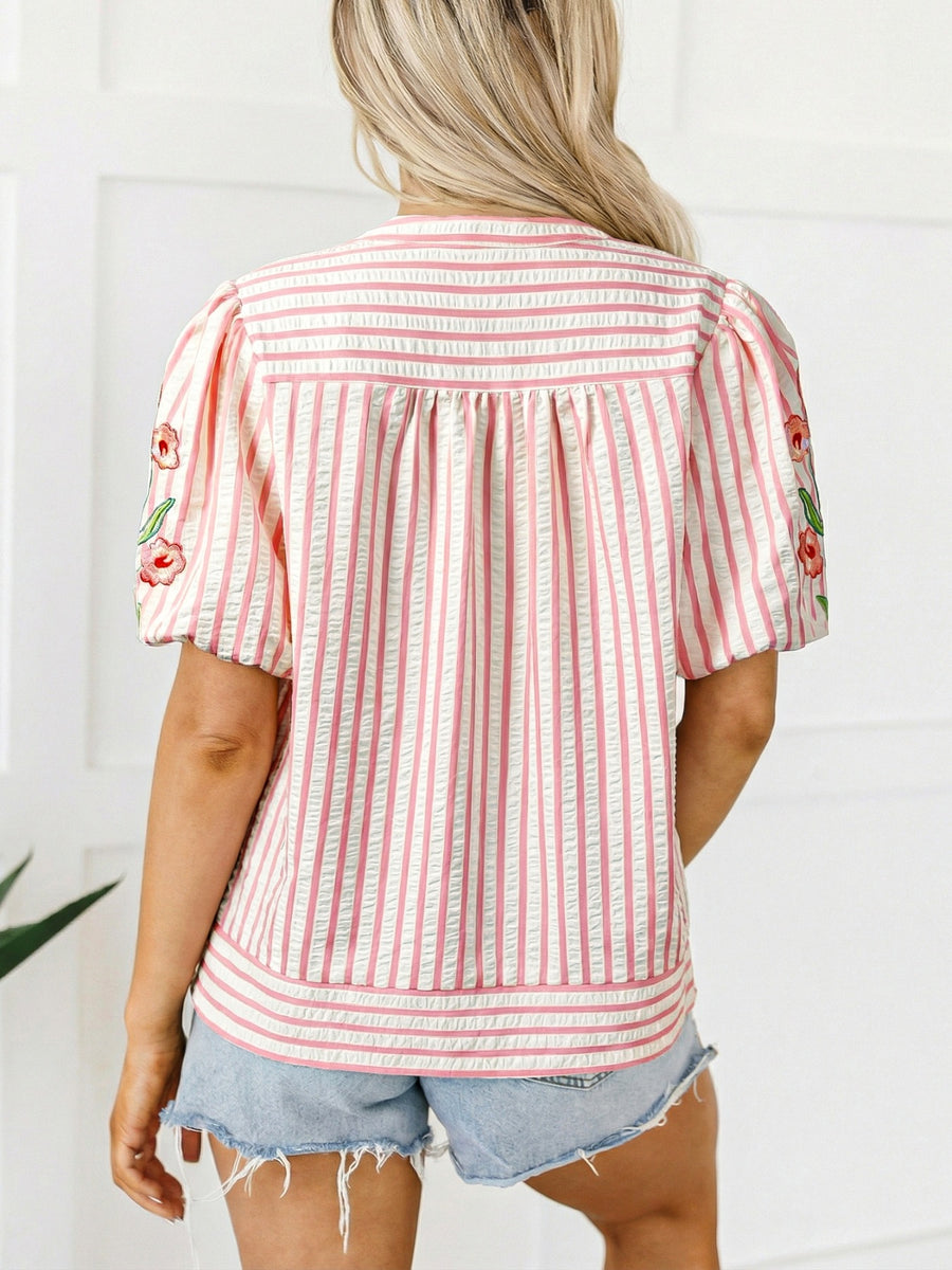 Pink and white striped blouse with floral embroidery on puff sleeves and gathered back detail.