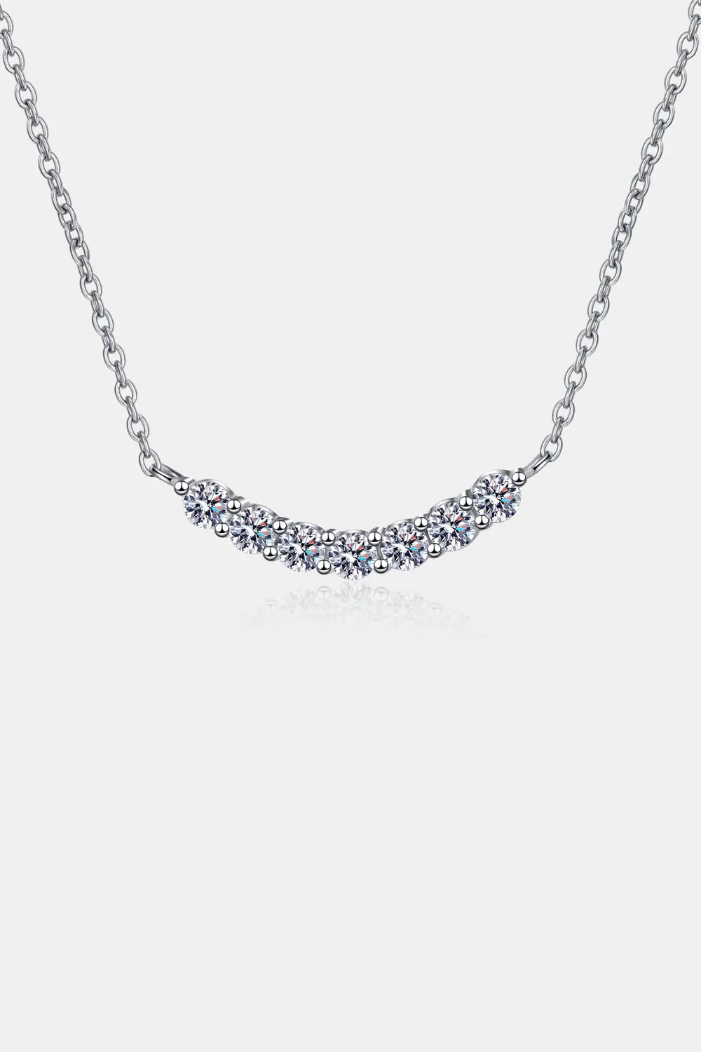 Silver moissanite necklace with a curved row of sparkling stones on a delicate chain.