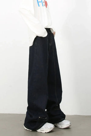 Dark denim trousers with sculptural seam details and wide leg