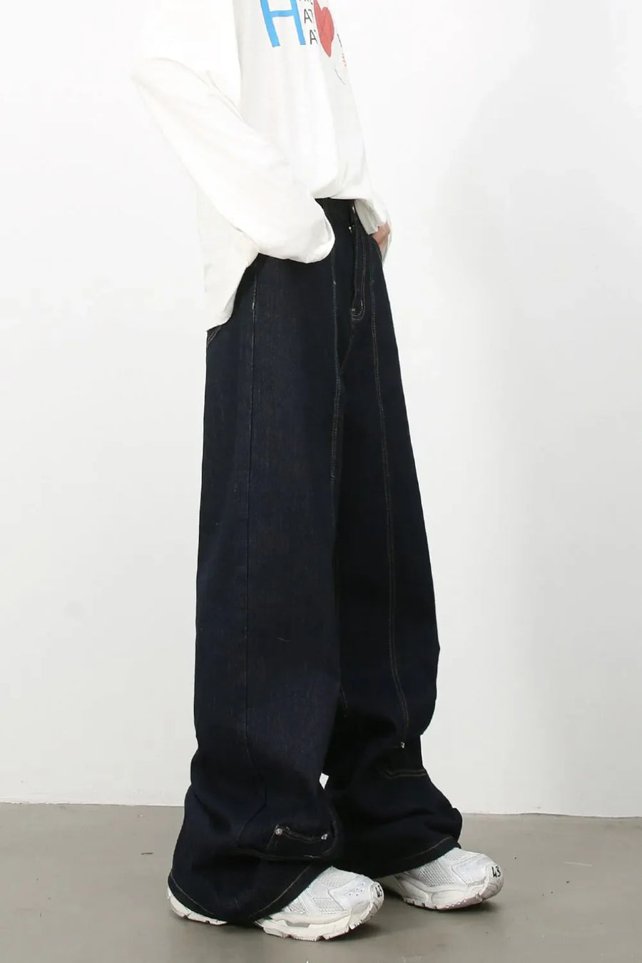 Dark denim trousers with sculptural seam details and wide leg