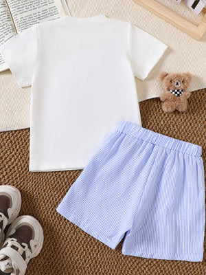 White baby tee with sailboat appliqué and blue striped shorts.