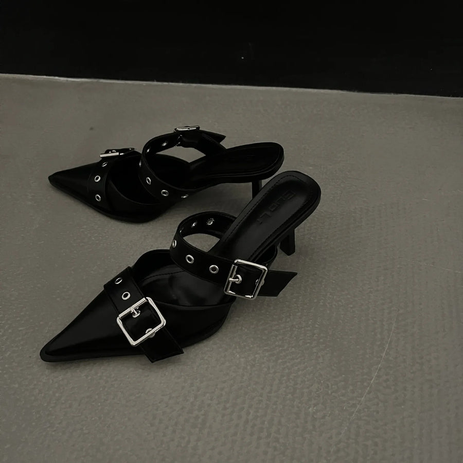 Black pointed buckle mules with silver hardware and double straps.